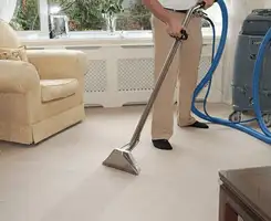 Carpet cleaning professional removing dirt and stains with a hot-water extraction tool in a home, Orange, CA.